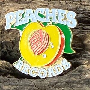 Colorful enamel Peaches Records logo pin from NOLALapelPins. Iconic design for f